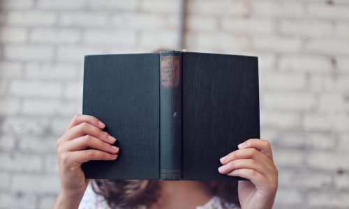 selective focus photography of woman holding book