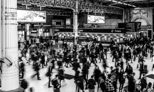 grayscale photography of people walking in train station