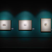 three paintings hanging in gallery