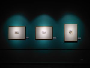 three paintings hanging in gallery