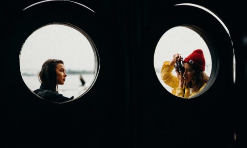 two women near windowpane