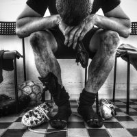 man in black pants and black and white sneakers sitting on chair
