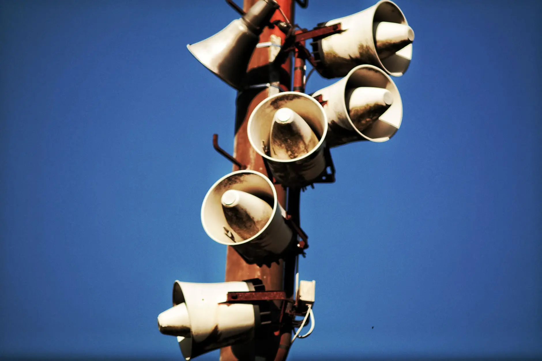 megaphone speakers on wooden post